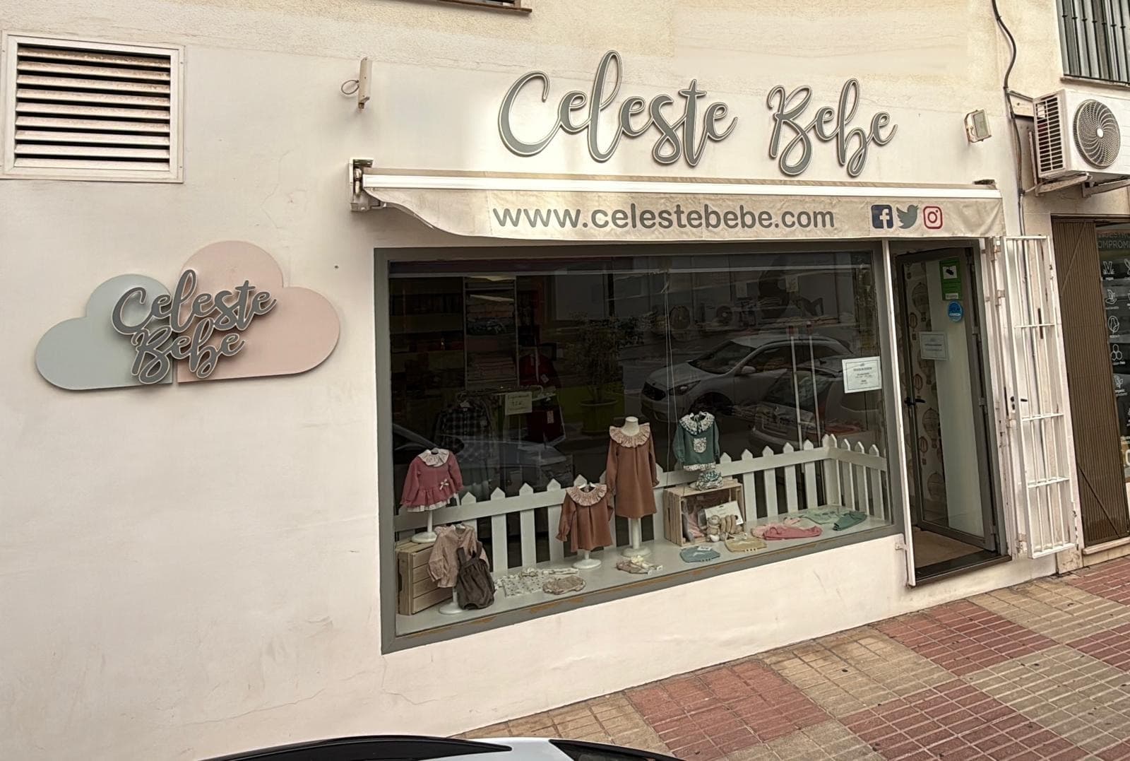 Fachada de la tienda Celeste Bebé en San Pedro de Alcántara, con su escaparate de ropa infantil